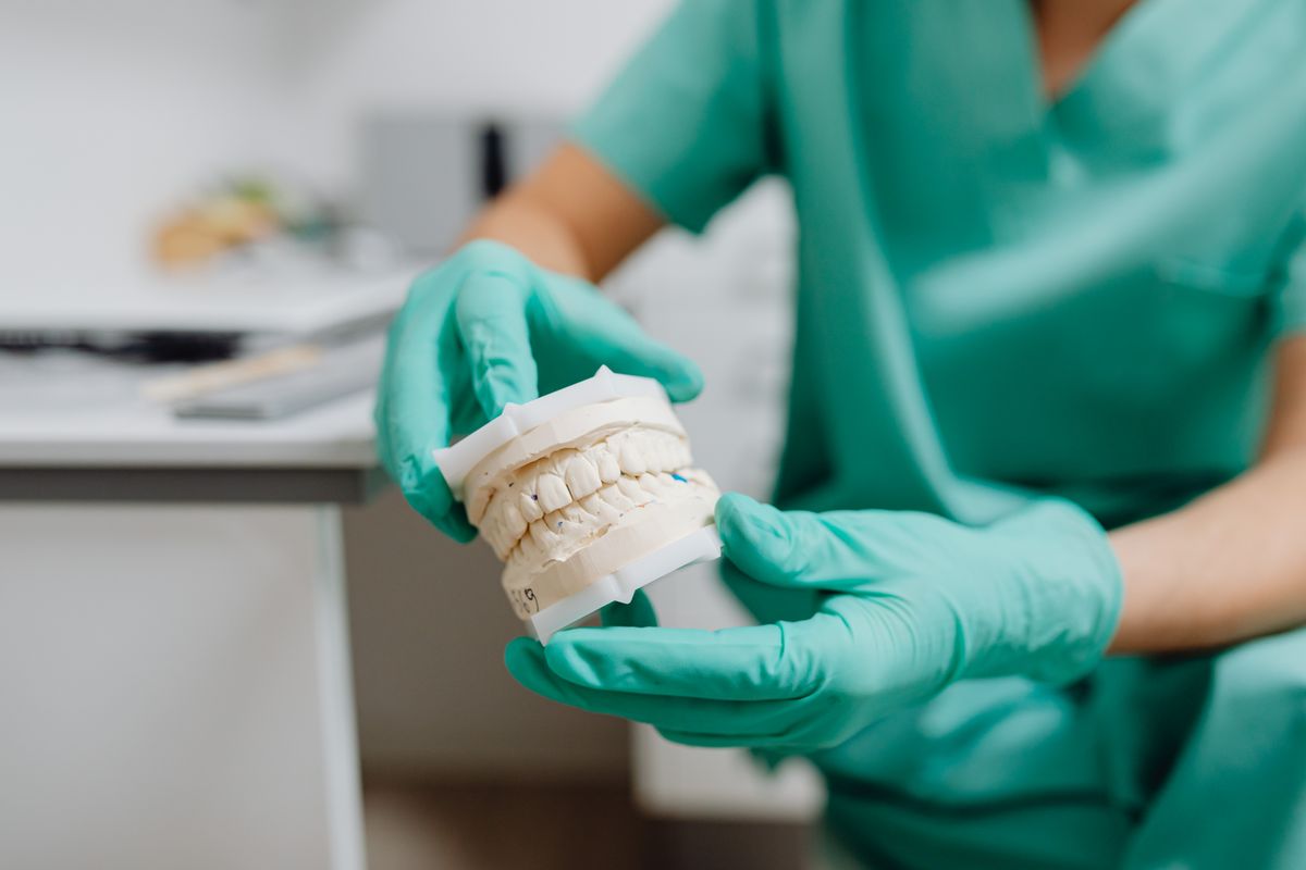 Technician reviewing a dental cast at the bench